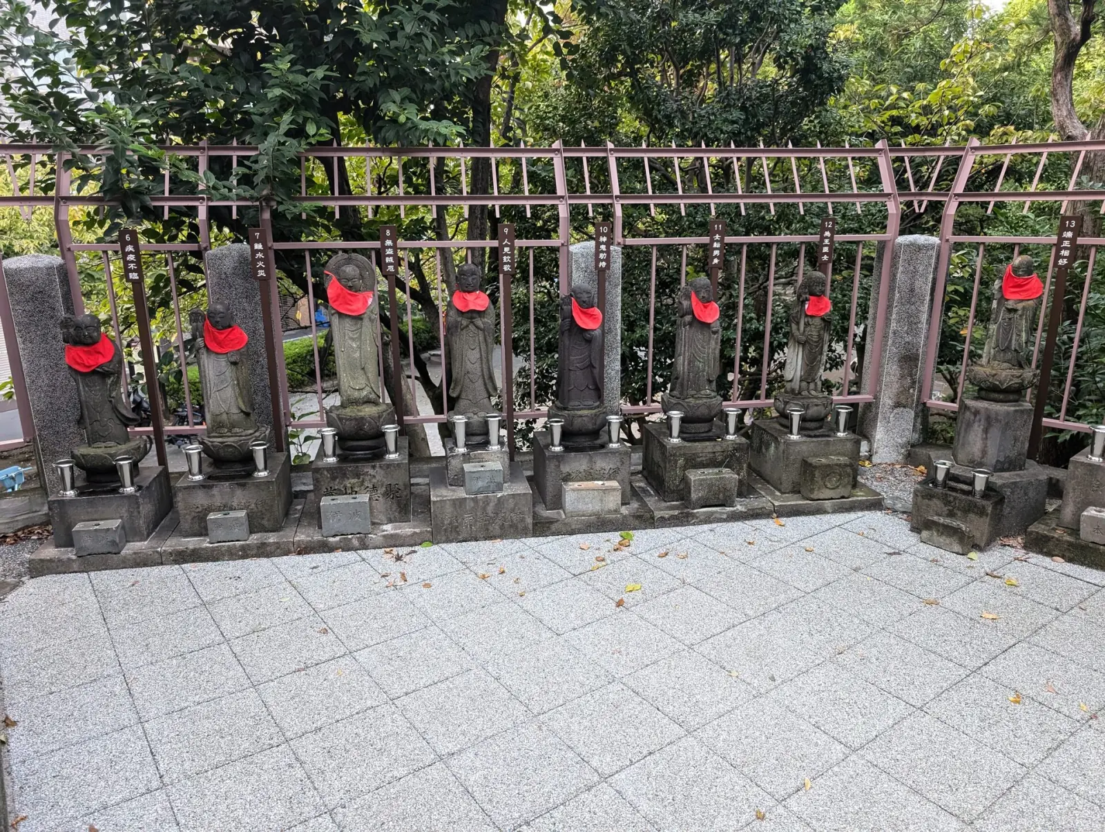 Row of Jizo stone statues wearing red bibs at an Asakusa temple in old Tokyo