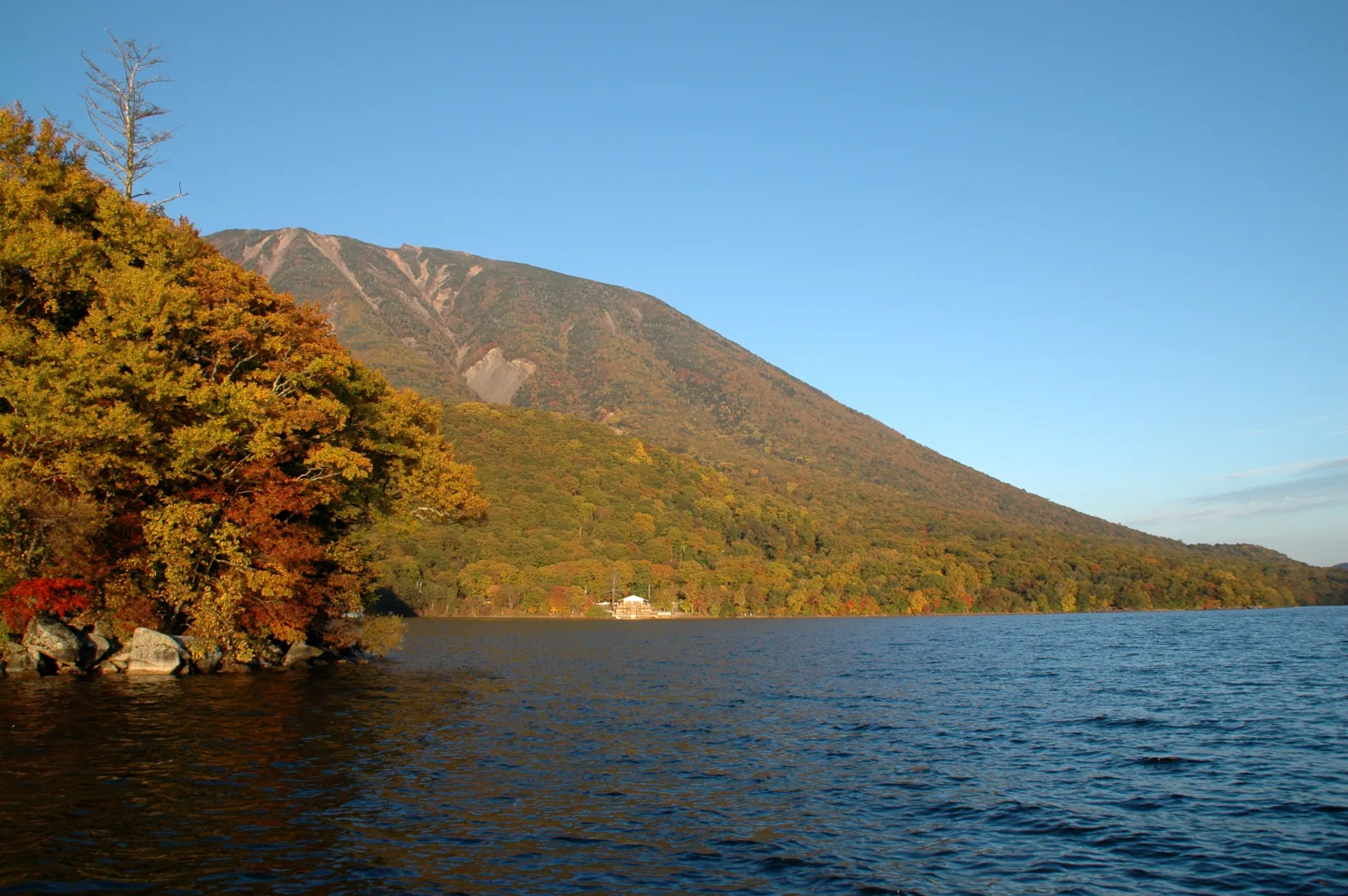 Follaje otoñal alrededor del lago Chuzenji en Nikko, con el monte Nantai detrás