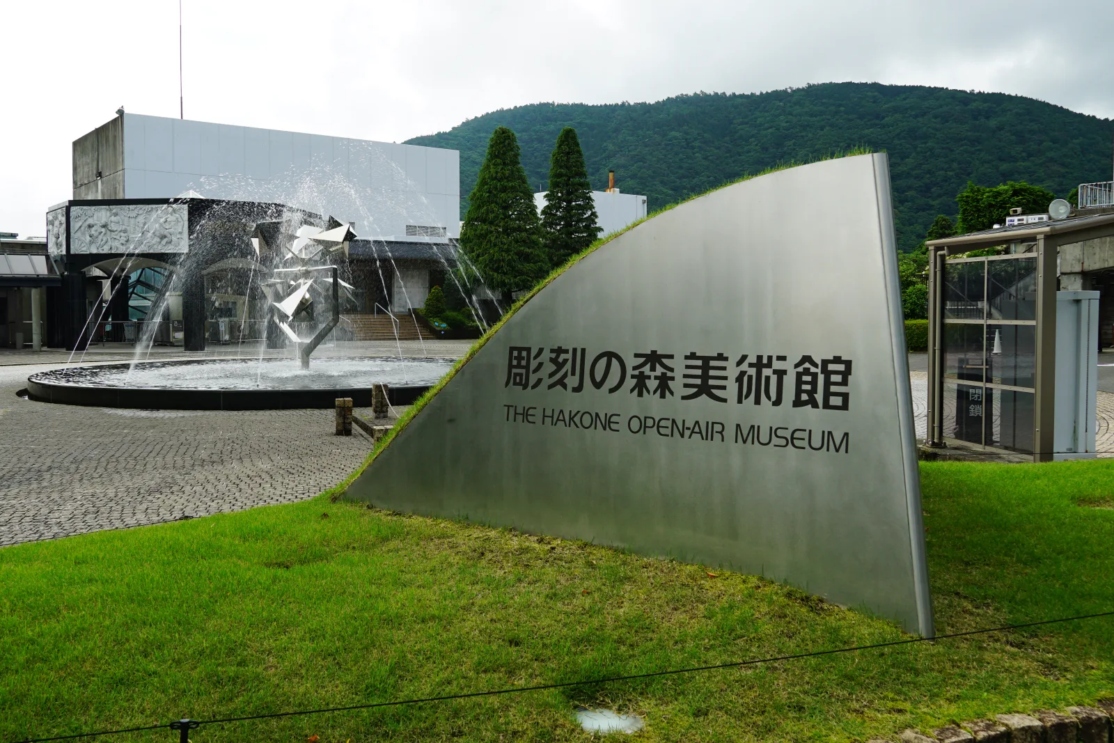 Escultura al aire libre en el Museo al Aire Libre de Hakone, con colinas boscosas al fondo