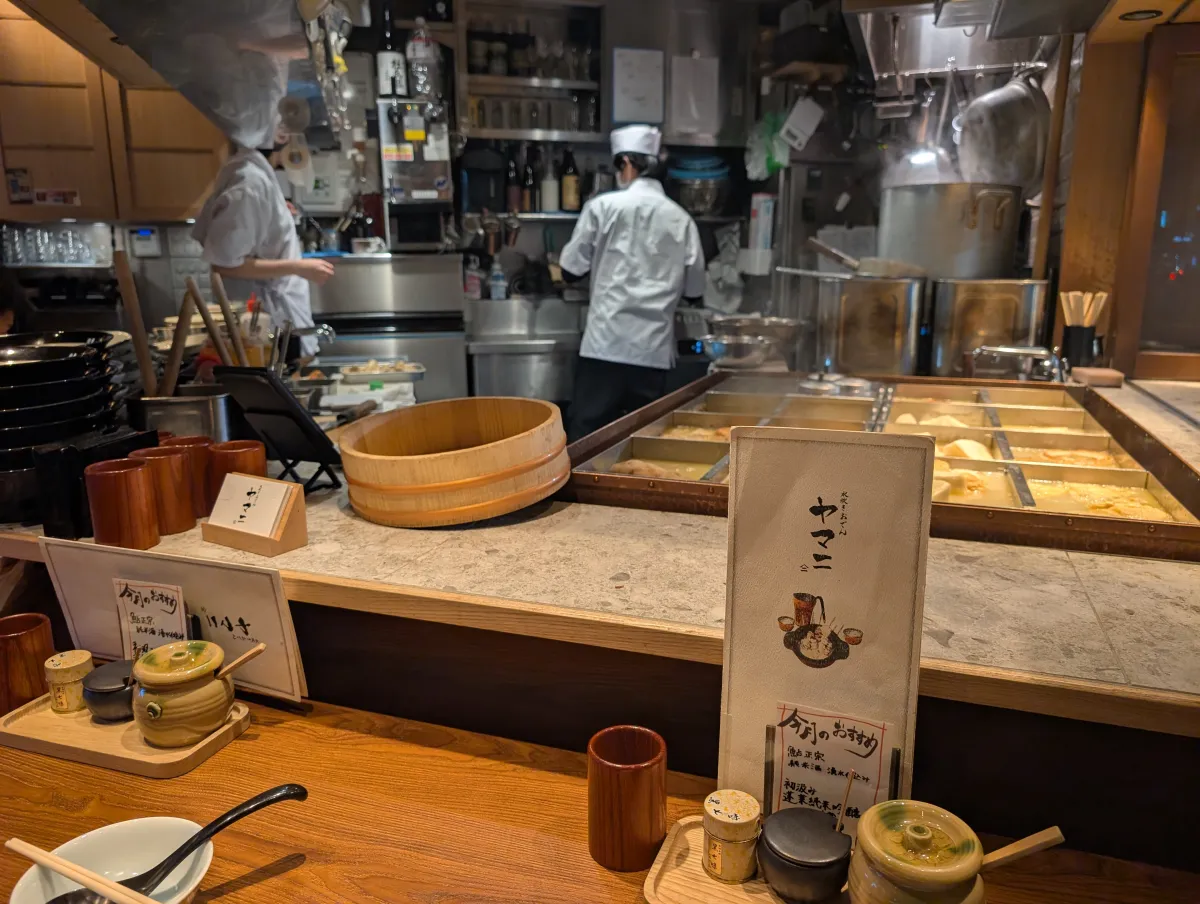 Asientos de barra en un restaurante de oden de Shinbashi con cocineros trabajando detrás