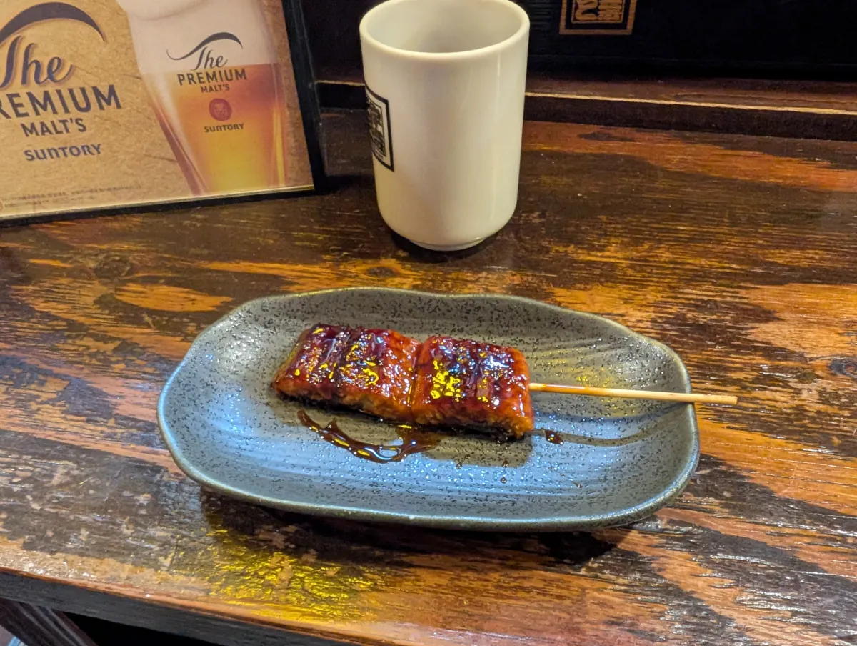 Brocheta de unagi a la parrilla con salsa tare en un izakaya de Shinbashi