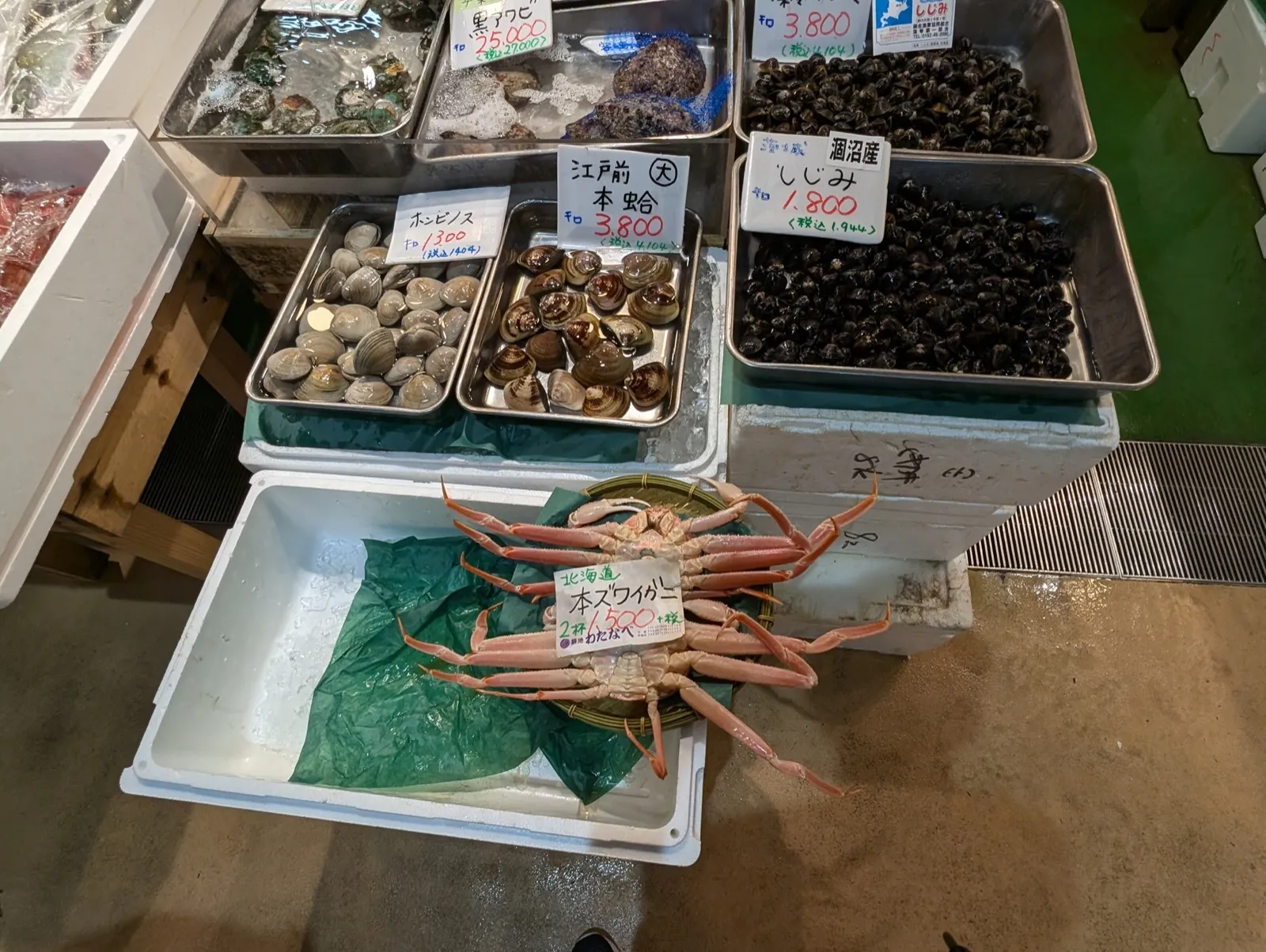 Fresh snow crab and assorted shellfish including clams and shijimi at a Tsukiji market stall