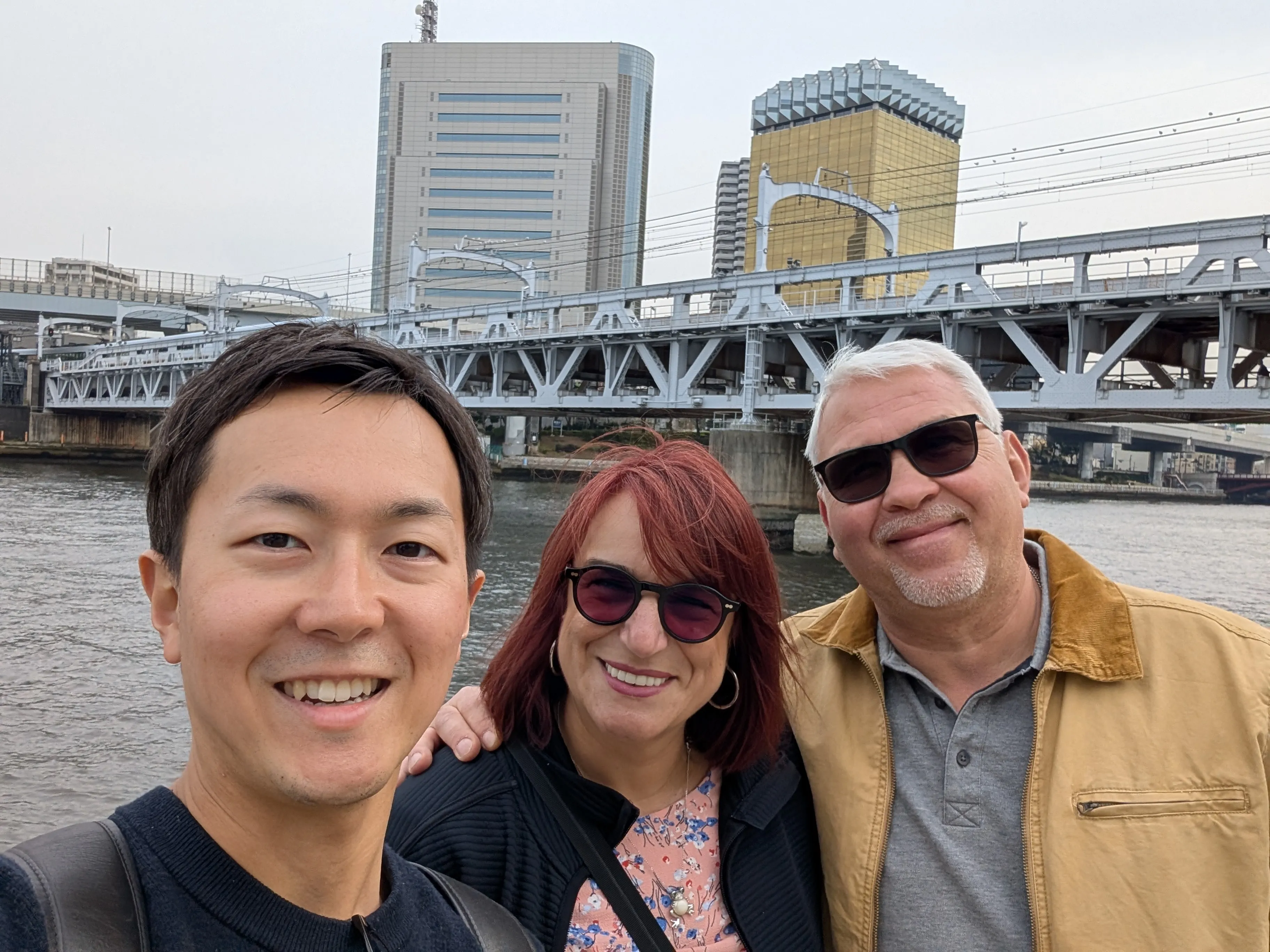 Selfie with guests by the Sumida River near Asakusa with Asahi Beer Tower in the background