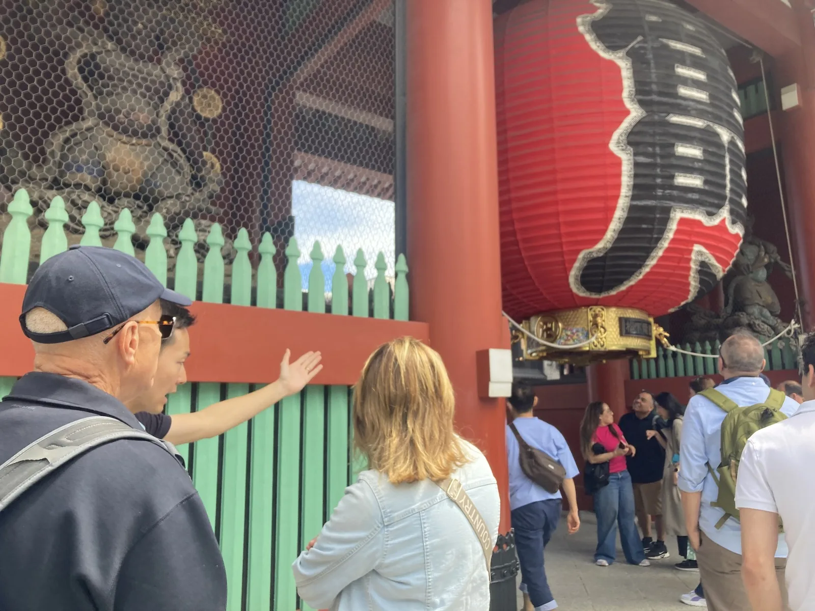 Manabu pointing out the hidden dragon carving beneath the Kaminarimon lantern in Asakusa